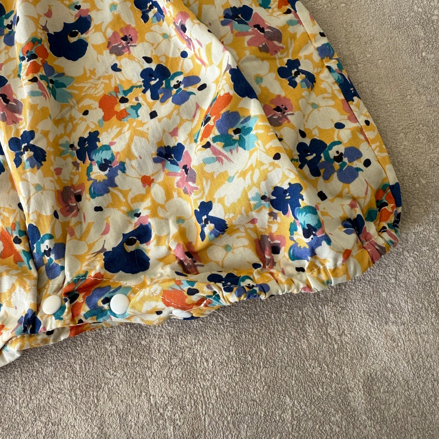 Blauw/geel bloemen rompertje